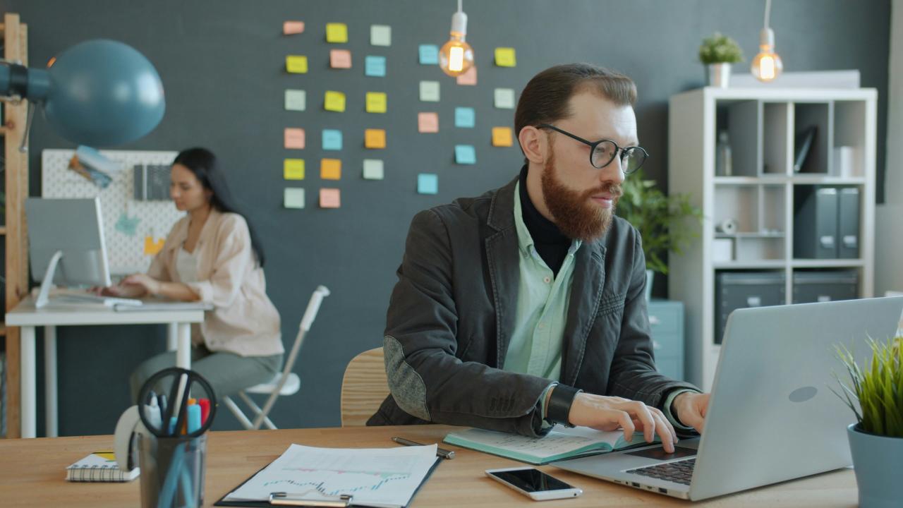 Man and woman working in modern office setting.